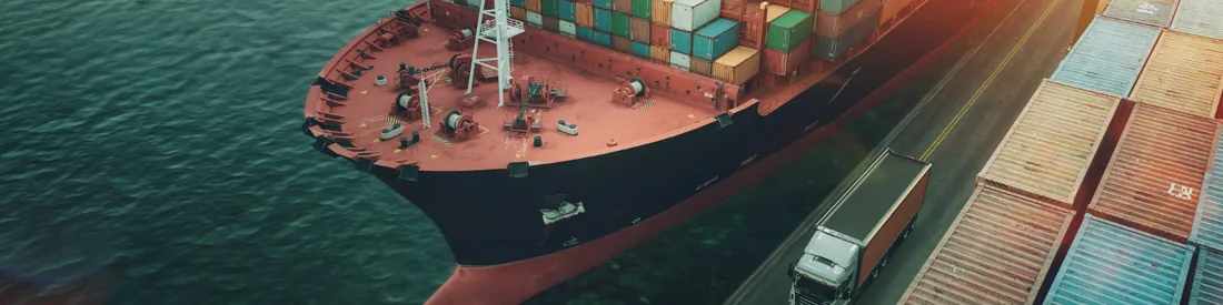 Navio porta-contêineres atracado ao lado de um caminhão no pátio do porto