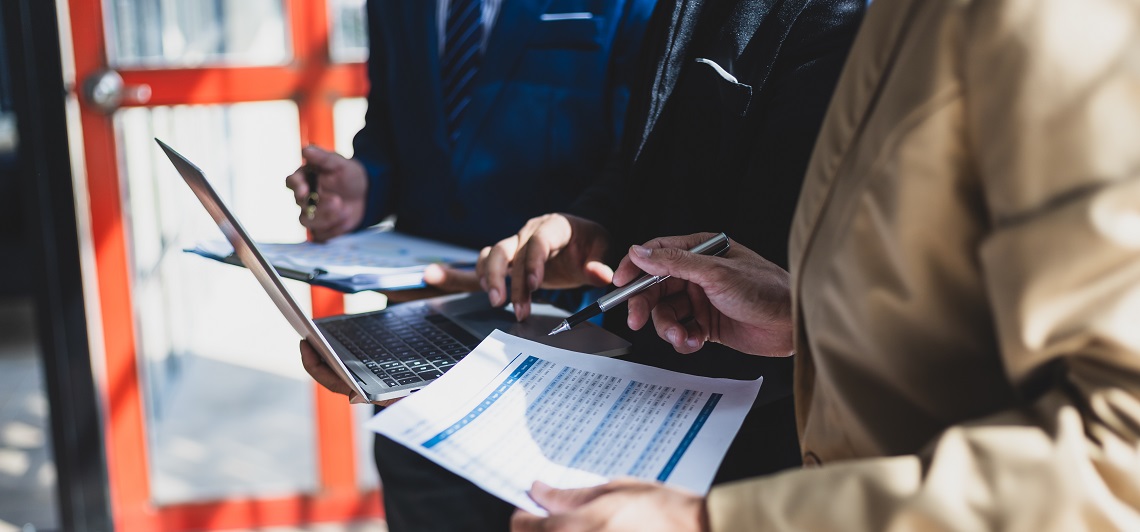 Executivos comparando importação direta x trading em operação de comércio exterior